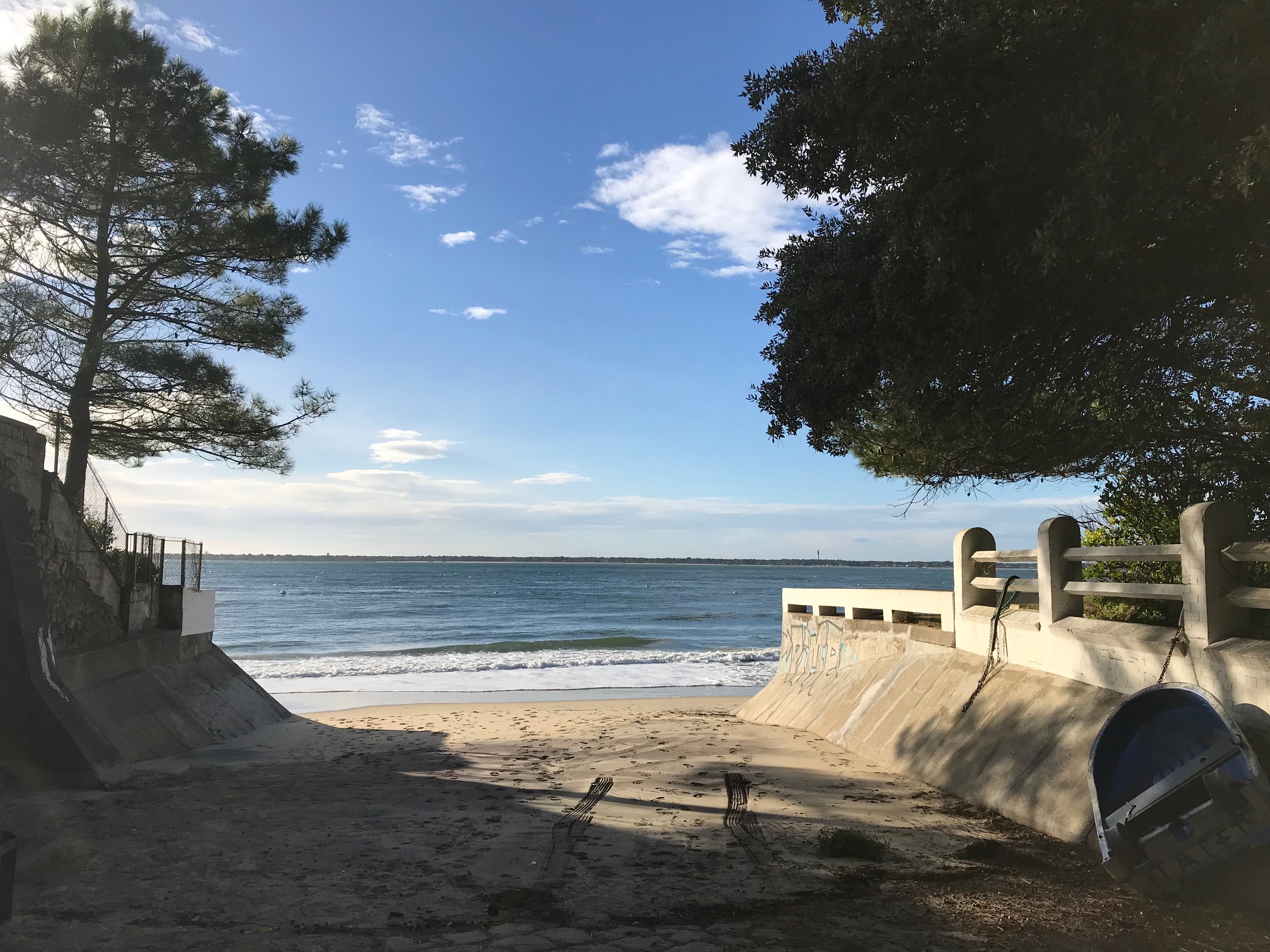 Accès à la plage au Pyla-sur-Mer entre les arbres, avec vue sur le Bassin d’Arcachon.